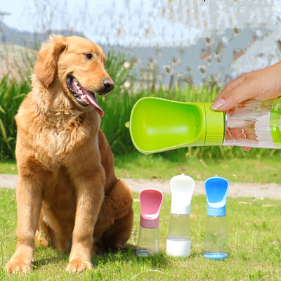 犬が水飲み器で水を飲むために水筒を持っていく